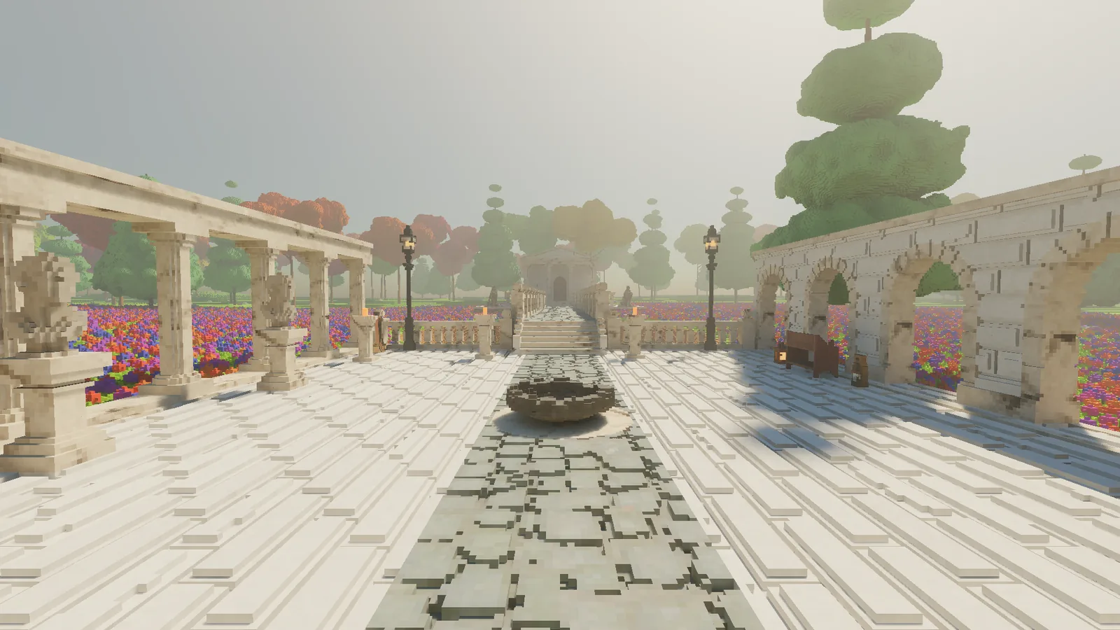 Looking down the paved courtyard along a cobbled path toward the bridge, with the colonnade on the left and the arcade on the right.