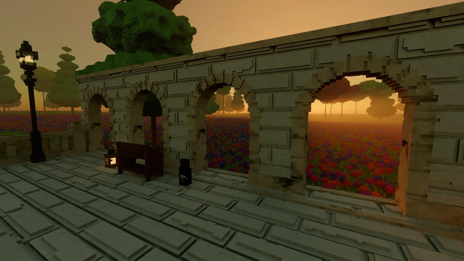 The arcade at dusk, the sunset glowing through its arches, with a lantern beside a bench and a street lamp.