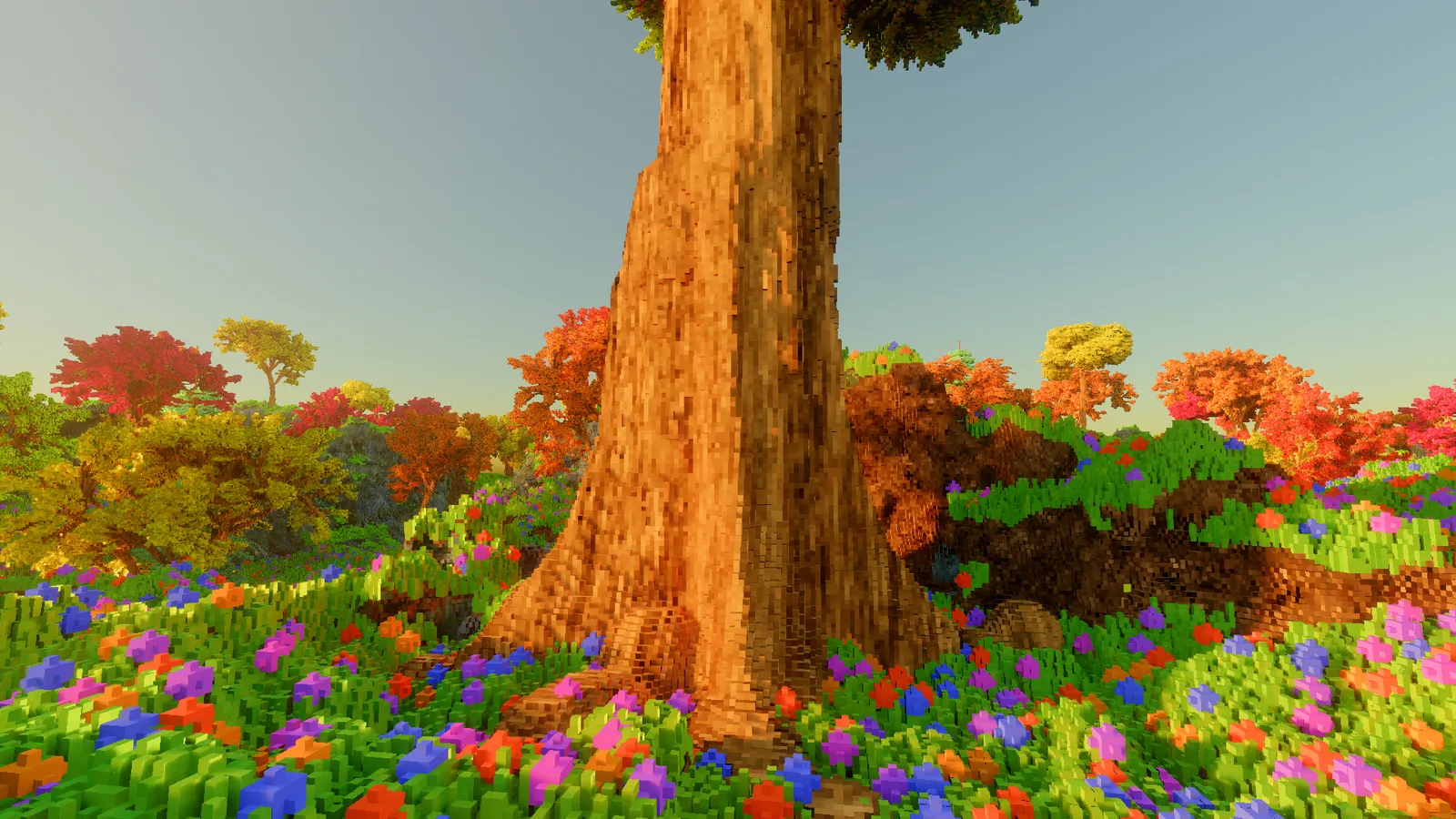 The base of a huge tree trunk with folded bark, rising out of a dense flower meadow, with smaller autumn trees behind.